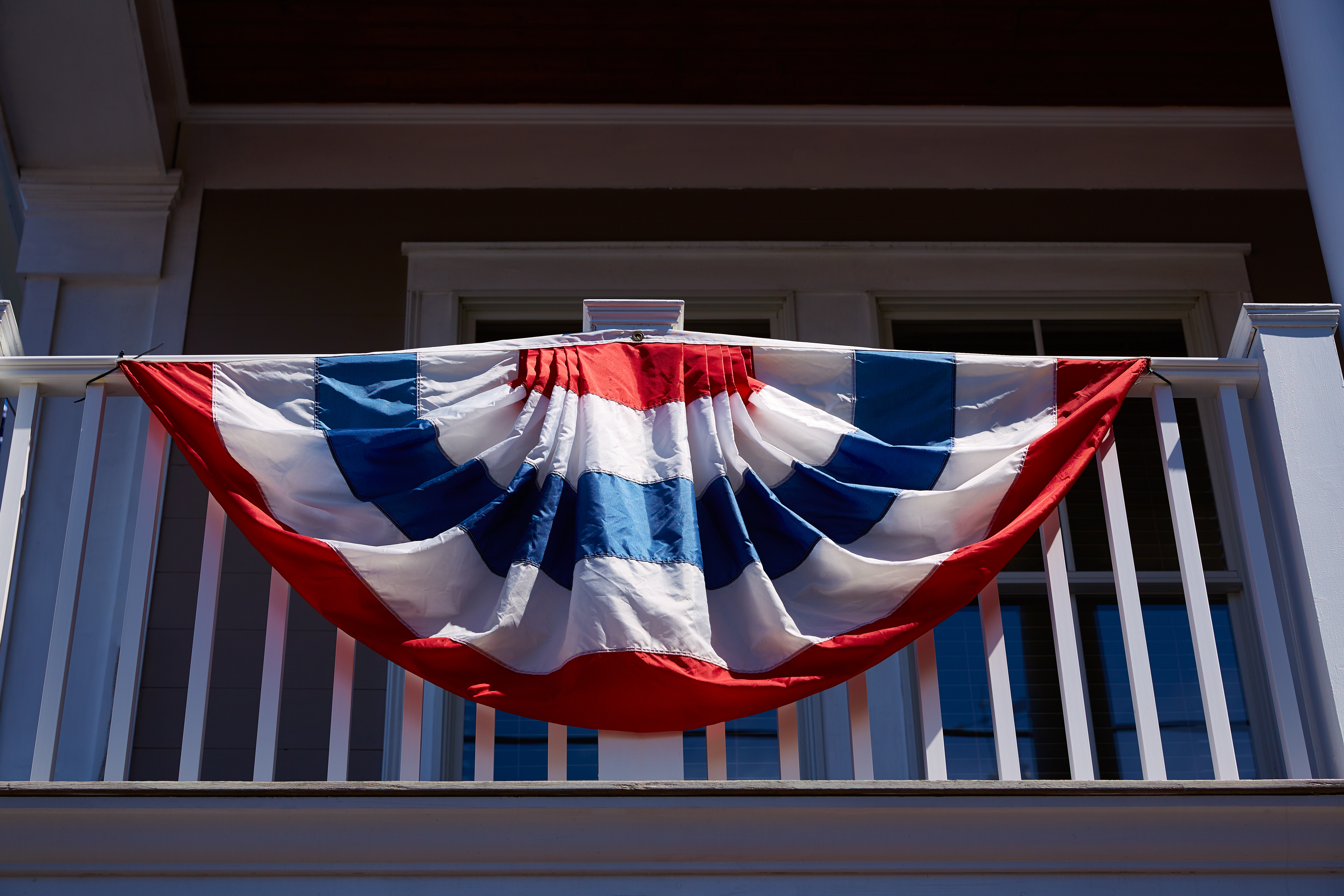 blog image of american flag on an apartment balcony; blog title: 3 Ways to Celebrate the True Meaning of Memorial Day