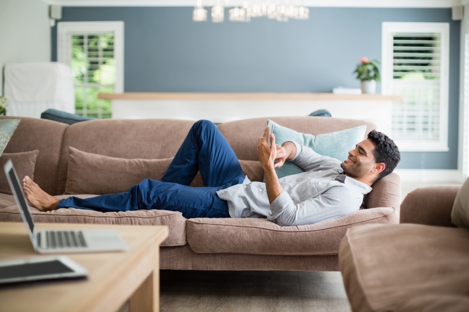 blog image of a man laying on his apartment couch using a cell phone