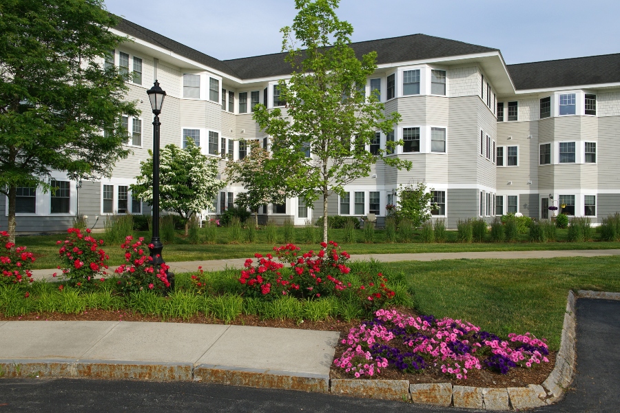 image of an attractive apartment exterior with pink and red flowers