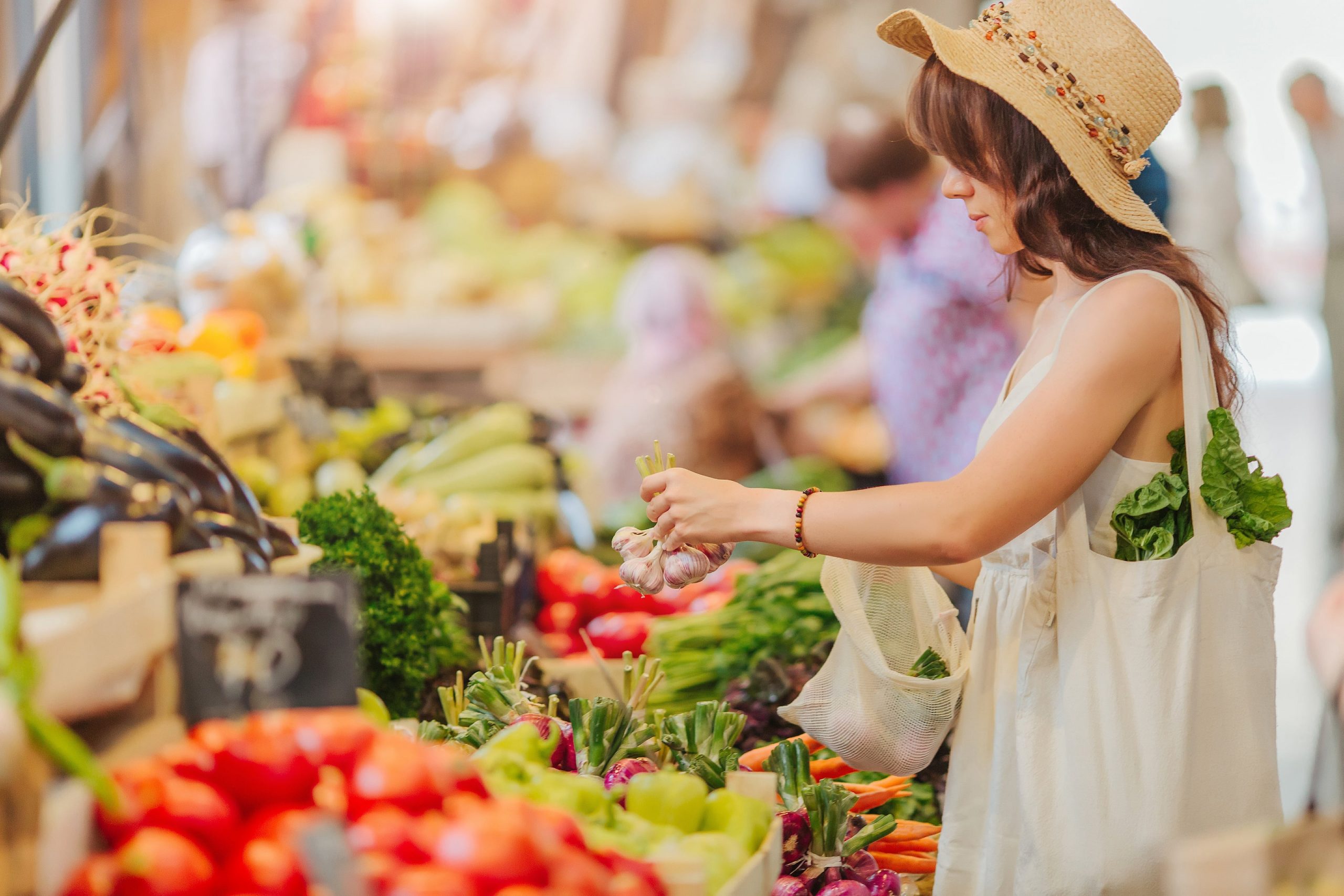 image of woman browsing produce at the farmers market